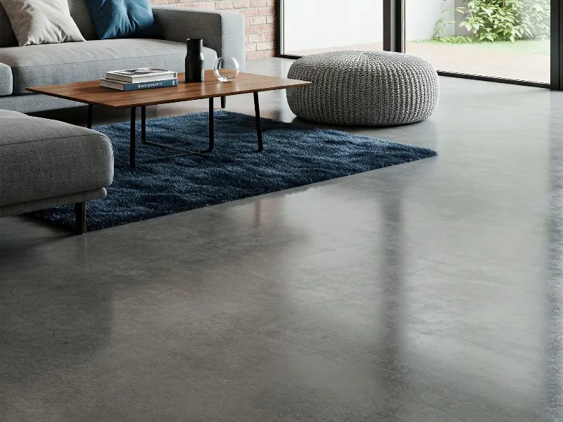 Polished concrete floors with neutral jute area rug and modern leather sofa in minimalist space.