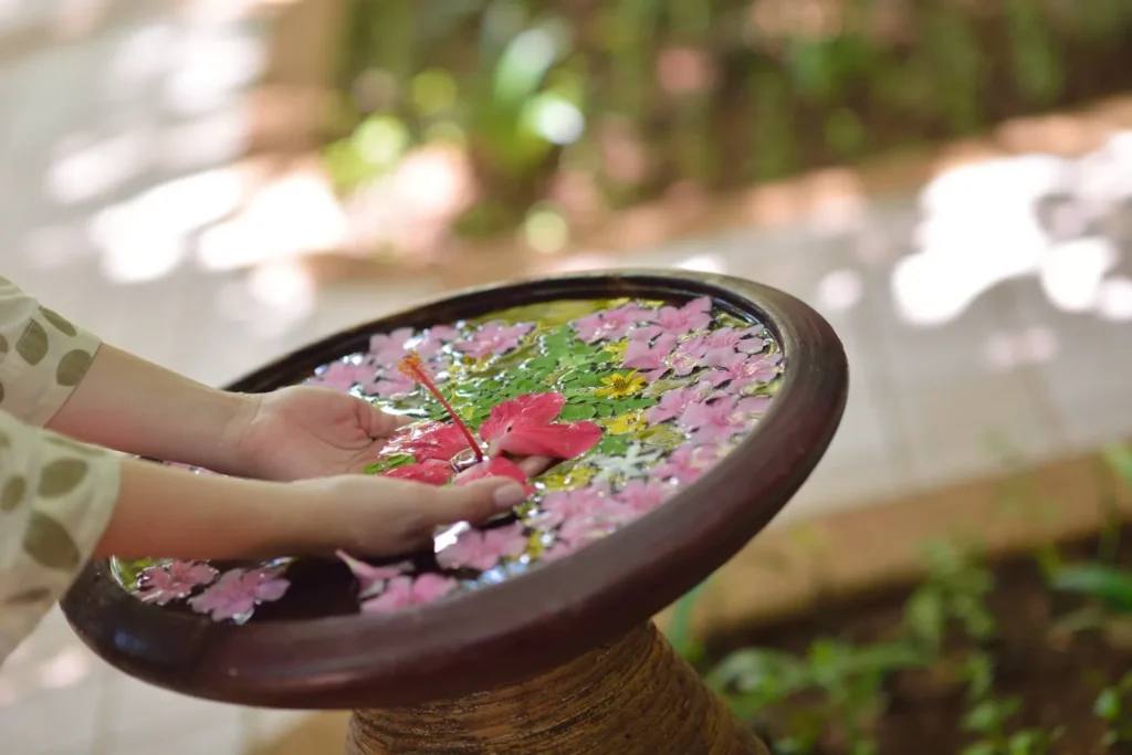 A DIY birdbath made from an old ceramic bowl, providing a peaceful water feature for the garden.