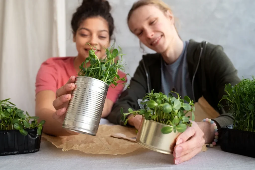 DIY tin can planters painted in vibrant colors for a charming and budget-friendly garden decor idea.